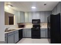 Functional kitchen featuring gray cabinets, marble countertops, and black appliances at 5851 Giles Rd, Lithonia, GA 30058