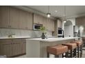 Modern kitchen with stainless steel appliances, sleek cabinets, a marble backsplash, and a center island with seating at 799 Grande Bishop Dr, Fairburn, GA 30213
