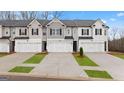 New construction townhomes boasting white garage doors, manicured lawns, and charming curb appeal at 322 Sound Cir # 118, Stockbridge, GA 30281