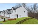 Exterior side view of newly built townhomes surrounded by lush green grass and trees at 322 Sound Cir # 118, Stockbridge, GA 30281