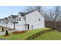 An exterior side-view showing a new home's well-maintained lawn and neighborhood fencing at 326 Sound Cir # 119, Stockbridge, GA 30281