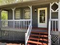 Inviting covered front porch with white railings and wood stairs leading to the front door at 275 Summertown Dr, Stockbridge, GA 30281