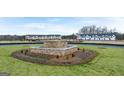 Community entrance featuring manicured landscaping, a central water feature, and newly constructed townhomes at 334 Sound Cir # 120, Stockbridge, GA 30281
