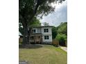 Charming two-story home featuring a welcoming front porch and mature trees at 1962 Compton Dr, Atlanta, GA 30315