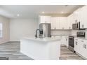 Modern kitchen with stainless steel appliances, white cabinets, granite countertops and a large kitchen island at 3353 Arabian Farm Ln, Dacula, GA 30019