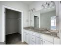 Bathroom features a double vanity with granite countertop and walk-in closet at 695 Park Place Way, Social Circle, GA 30025
