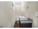 Modern powder room with a vessel sink on a dark cabinet, a toilet, and a small window at 1397 Thomas Rd, Decatur, GA 30030