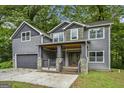 Charming two-story home with gray siding, stone accents, covered porch, and a two-car garage at 1397 Thomas Rd, Decatur, GA 30030