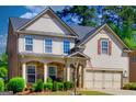 Charming two-story home featuring a stone porch, gray siding, and a well-manicured front yard at 5845 Princeton Run Trl, Tucker, GA 30084