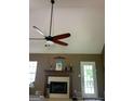 Comfortable living room with fireplace, wood mantle, and vaulted ceiling with fan at 128 Kelleytown Woods Dr, Mcdonough, GA 30252