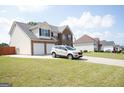 Beautiful two-story home with brick and siding, a two-car garage, and a lush green lawn at 65 Heaton Place Trl, Covington, GA 30016