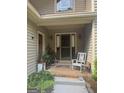 Inviting front porch with a welcoming rocking chair, plants, and stylish sconces at 1685 Bailey Creek Sw Rd, Conyers, GA 30094