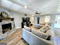 Comfortable living room with a stone fireplace, a large sectional sofa, and wood-look floors at 140 Whitehead Sw Rd, Oxford, GA 30054