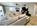 Cozy living room boasts a stone fireplace, a ceiling fan, and a comfortable sectional sofa at 140 Whitehead Sw Rd, Oxford, GA 30054