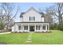 Charming two-story white home with a covered front porch and well-manicured lawn at 61 Main St, Moreland, GA 30259