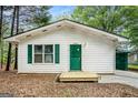 Charming single-story home with a covered carport, green shutters, and a well-maintained front lawn at 3118 Rockbridge Rd, Avondale Estates, GA 30002
