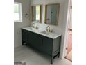 Bathroom featuring double sink vanity with white countertop, green cabinets, and gold fixtures at 854 Clearwater Rd, Sharpsburg, GA 30277