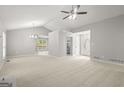 Spacious living room with neutral carpet, a modern ceiling fan, and plenty of natural light at 40 Kelsey Way, Palmetto, GA 30268