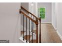 A staircase features dark wood railings and white painted risers, leading to the second floor at 115 Oak Road, Locust Grove, GA 30248