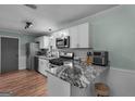 Bright kitchen featuring stainless steel appliances, granite countertops, white cabinets and bar seating at 235 Castlegate Cir, Carrollton, GA 30116