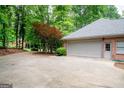 Spacious two-car garage featuring a large driveway and mature trees at 260 Emerald Lake Dr, Fayetteville, GA 30215