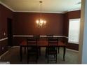 Formal dining room featuring neutral carpet, crown molding, and a hanging chandelier at 6974 Chilkat Sw Ct, South Fulton, GA 30331