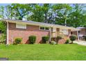 View of brick house with well-maintained lawn and manicured shrubs at the facade at 322 E Rhinehill Rd, Atlanta, GA 30315
