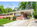 Brick house featuring a convenient carport and well-kept lawn on a sunny day at 322 E Rhinehill Rd, Atlanta, GA 30315