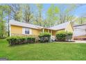 Home exterior featuring a well-maintained lawn, stone details, and white trim at 5998 Radford Dr, Riverdale, GA 30296