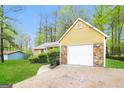 Exterior view of home showcasing the attached garage with a white door and stone accents at 5998 Radford Dr, Riverdale, GA 30296