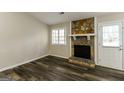 Cozy living room with a stone fireplace, dark wood floors, and natural light at 5998 Radford Dr, Riverdale, GA 30296