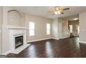 Bright living room with a fireplace, ceiling fan, hardwood floors, and access to the staircase at 7481 Absinth Dr, Atlanta, GA 30349