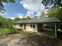 Home exterior featuring an attached carport, metal roof, and neutral siding at 132 N Johnson St, Bowdon, GA 30108