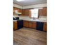 Practical kitchen layout with black appliances, laminate countertops, and wood-look vinyl flooring at 8672 Bowden St, Douglasville, GA 30134