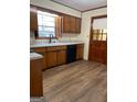 Cozy kitchen with wood cabinets, laminate countertops, and wood-look vinyl flooring at 8672 Bowden St, Douglasville, GA 30134