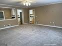 Open-concept living room featuring neutral paint, carpet, and views into the kitchen area at 8660 Bowden St, Douglasville, GA 30134