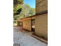 View of a side entrance, brick exterior, and a detached garage/carport area at 8660 Bowden St, Douglasville, GA 30134