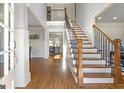 Bright foyer with hardwood floors, elegant staircase with iron railings, and neutral walls at 8710 Gilmer Ft, Cumming, GA 30028