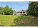Traditional white home with a welcoming porch and expansive front lawn at 138 Sam Solomon Rd, Locust Grove, GA 30248