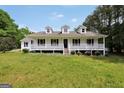 Inviting white home boasts a covered porch and well-maintained front yard at 138 Sam Solomon Rd, Locust Grove, GA 30248