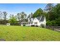 A beautiful two-story home with a large, well-manicured front lawn surrounded by lush trees at 614 Highway 85 Conn, Brooks, GA 30205