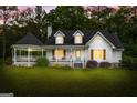 The front of this lovely two-story home is lit up at dusk, highlighting its charming details at 614 Highway 85 Conn, Brooks, GA 30205