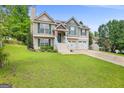 Charming home with a two-car garage, white stairs, and a manicured front yard at 103 Manx Dr, Grantville, GA 30220