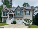 Two-story home featuring a lush green lawn, solar panels, and a convenient two-car garage at 103 Manx Dr, Grantville, GA 30220