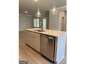 Kitchen island featuring white cabinets, stainless steel dishwasher, sink, and granite countertops at 3708 Cheswolde Ave # 95, Powder Springs, GA 30127