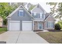 Charming two-story home featuring stone accents, gray siding, a well-manicured lawn, and a convenient two-car garage at 3313 Bethesda Ter, Acworth, GA 30101