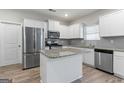 Modern kitchen with white cabinets, stainless steel appliances, granite countertops, and a stylish island at 8069 Louis Dr, Locust Grove, GA 30248