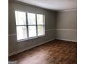 Bright living room featuring a large window and beautiful hardwood floors at 1023 Falling Water Se Dr, Smyrna, GA 30080