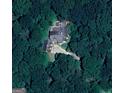 Aerial view of a home surrounded by greenery with a long driveway winding through lush trees at 145 E Lake Dr, Mountain Park, GA 30075