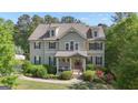 Beautiful two-story home with dormer windows, a manicured lawn, and a charming covered front porch at 335 Discovery Lake Dr, Fayetteville, GA 30215